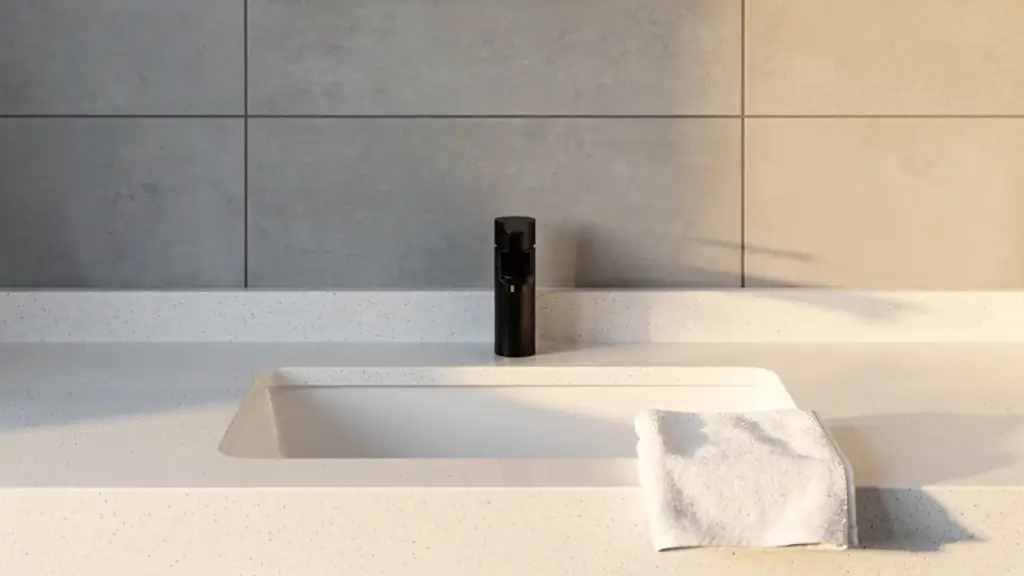 A clean white vanity with a matte black faucet and a folded white towel